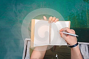 Man writing pen in book
