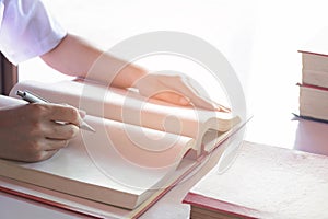 Man writing pen in book on white table