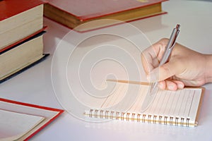 Man writing pen in book on white table