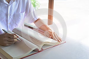 Man writing pen in book on white table