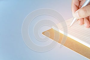 Man writing pen in book on white table