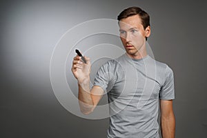 Man writing something with marker on glass board.