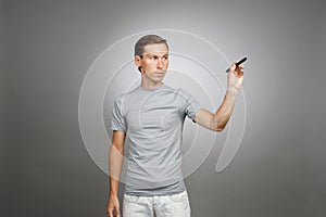 Man writing something with marker on glass board.