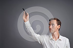 Man writing something with marker on glass board.