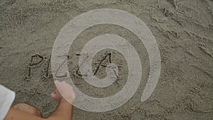 Man is writing a text on the sand of the beach