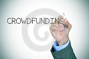 Man writing the word crowdfunding photo