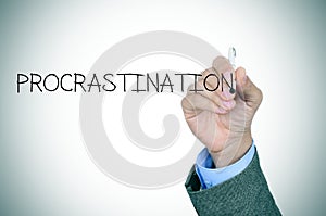 Man writing the word procrastination photo