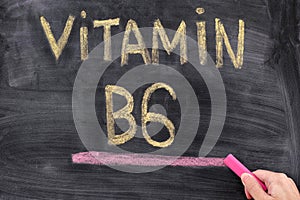 Man writing words Vitamin B6 on chalkboard