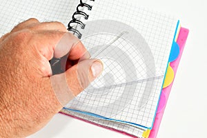 A man& x27;s hand flips through a notebook.