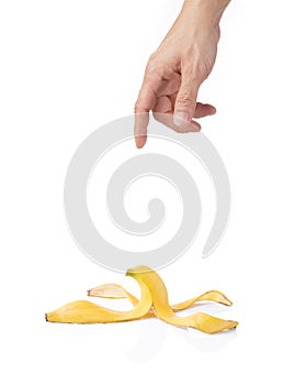 Man's hand reaching for a peeled banana skin