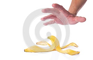 Man's hand reaching for a peeled banana skin