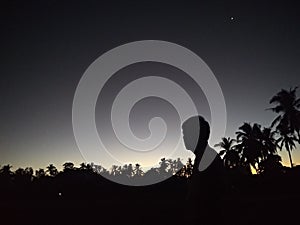 A man& x27;s sillouette meditating on a silent dark night. photo