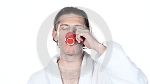 Man yawning mouth covering his hand, drinking coffee. White background