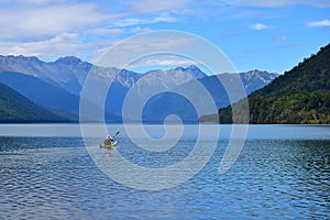 A man paddling across Lake Rotoroa in the Nelson Lakes National Park, New Zealand, South Island