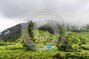 Man on yellow hammock in summer mountains