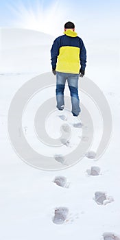 Man in yellow jacket walking on snow