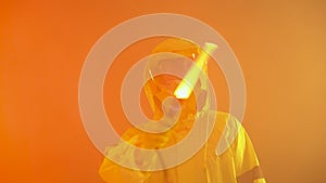 Man in yellow protective suit points the direction with a glowing wand. Man in smoke with a wand Signalling way