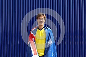 The man in yellow shirt with Australia flag on his shoulder