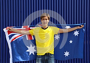 The man in yellow shirt is holding Australia flag on his shoulder