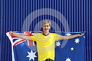 The man in yellow shirt is holding Australia flag on his shoulder