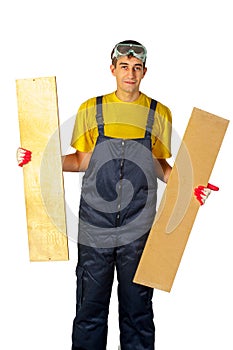 Man in the yellow shirt in overalls holding two boards