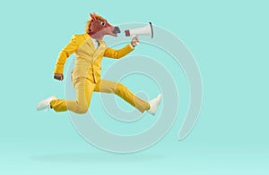 Man in yellow suit and funny horse mask flying in air and speaking through megaphone