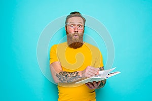 Man with yellow t-shirt and beard is surprised about something