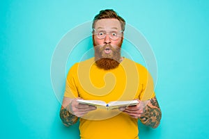 Man with yellow t-shirt and beard is surprised about something