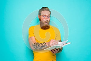 Man with yellow t-shirt and beard is surprised about something