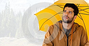 Man with yellow umbrella in bright forest