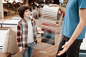 Man with young boy chooses color on color palette. Selecting color of mattress on color palette guide