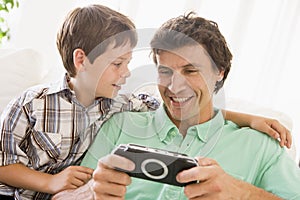 Man and young boy with handheld game photo