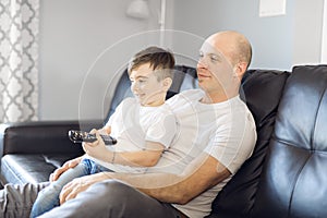 Man and young boy with remote control tv