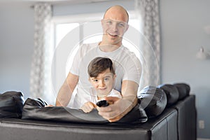 Man and young boy with remote control tv