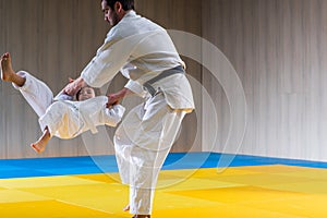Man and young boy are training judo