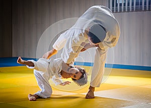 Man and young boy are training judo throw