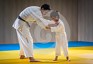 Man and young boy are training judo throw