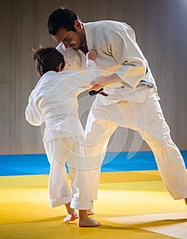 Man and young boy are training judo throw