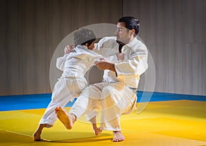 Man and young boy are training judo throw
