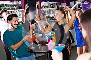 Man with young female are enjoying the party in bar.