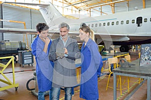 Man with young people in aircraft hangar