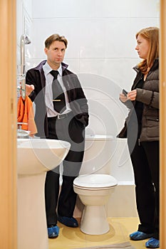 Man with young realtor look small and clean toilet