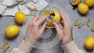 Man zesting lemon at grey table, closeup