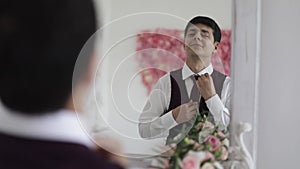 A man zips up a vest before a wedding celebration.