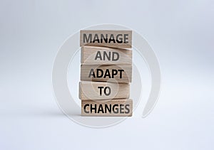 Manage and Adapt to Changes symbol. Wooden blocks with words Manage and Adapt to Changes. Beautiful white background. Business and