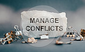 MANAGE CONFLICTS text on peace of paper photo
