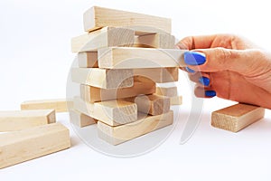 Manage risk concept with wooden blocks falling from structure