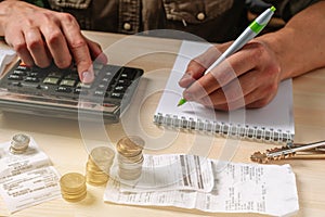 Manage your family budget planning, savings and payment concept. Close-up image of a man`s hand using a calculator calculates fina