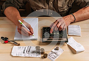 Manage your family budget planning, savings and payment concept. Close-up image of a man`s hand using a calculator calculates fina