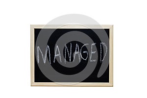 MANAGED written with white chalk on blackboard